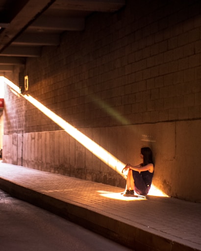 a person sitting on the ground in a tunnel