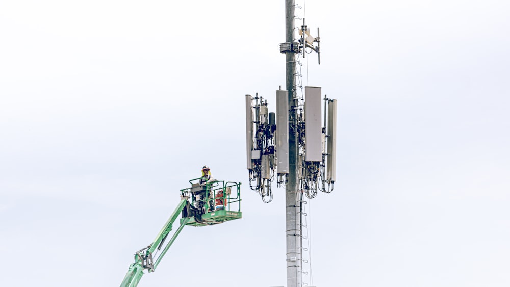 a man on a lift working on a cell phone tower