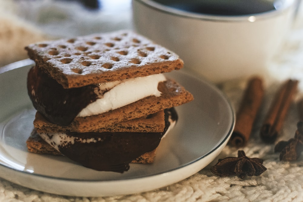 a stack of waffle sandwiches on a plate next to a cup of coffee