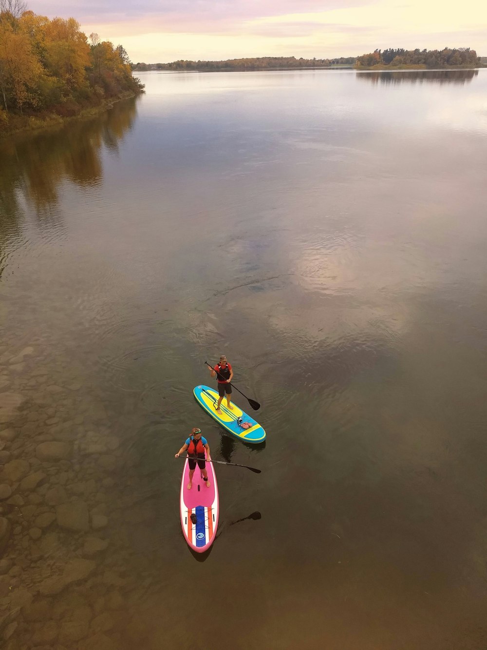 a couple of people on paddle boards in the water