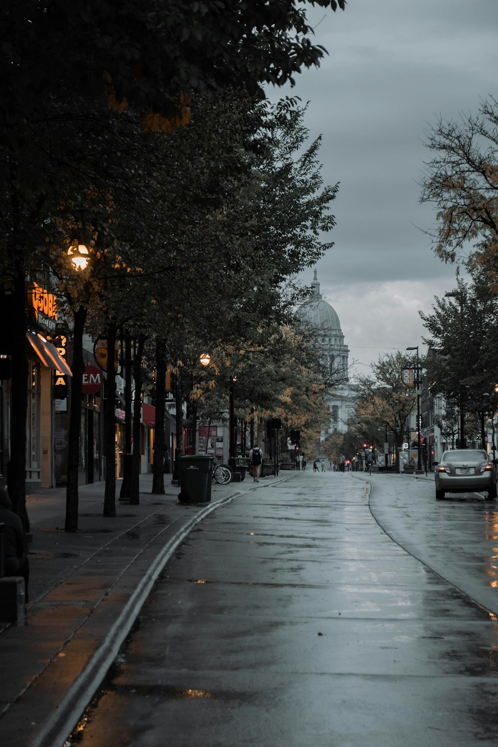 a city street at night with a car parked on the side of the road