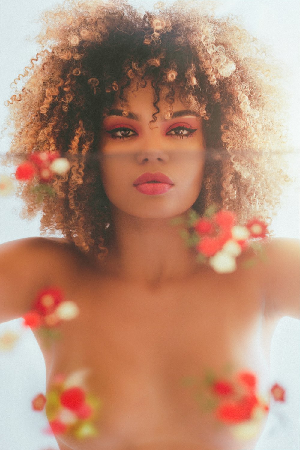 a naked woman with flowers around her neck
