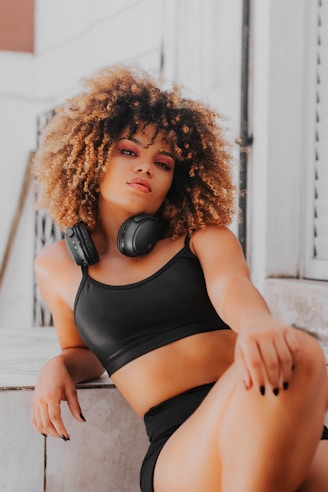 a woman wearing headphones sitting on a ledge