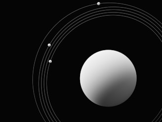 A minimalist design featuring a large, white sphere on a black background, surrounded by smaller white dots connected by thin curves in orbit-like paths.