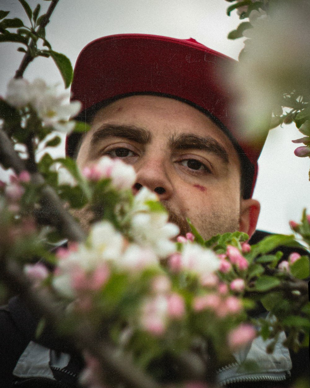 Un hombre con un sombrero rojo mirando a la cámara