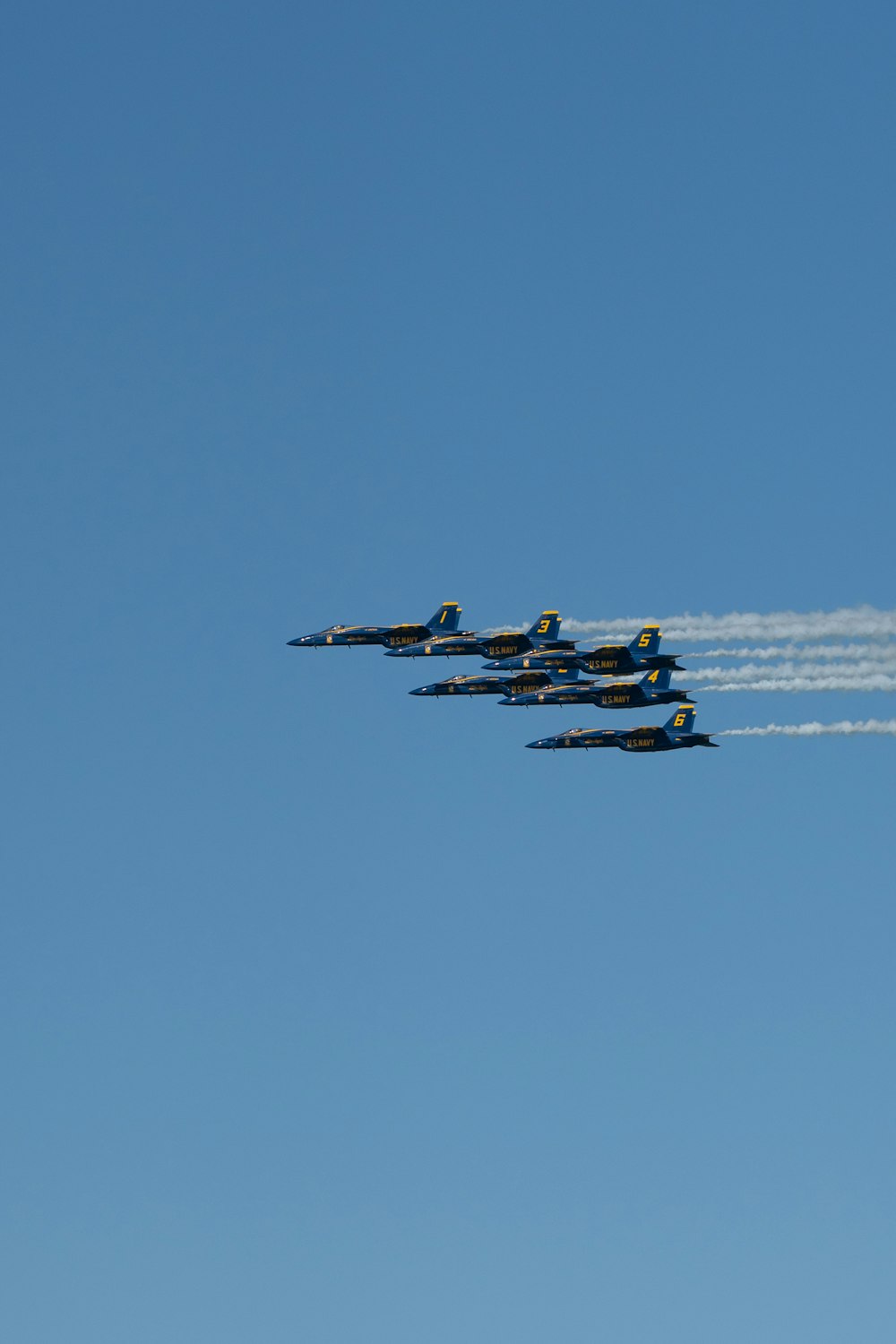 a group of fighter jets flying through a blue sky