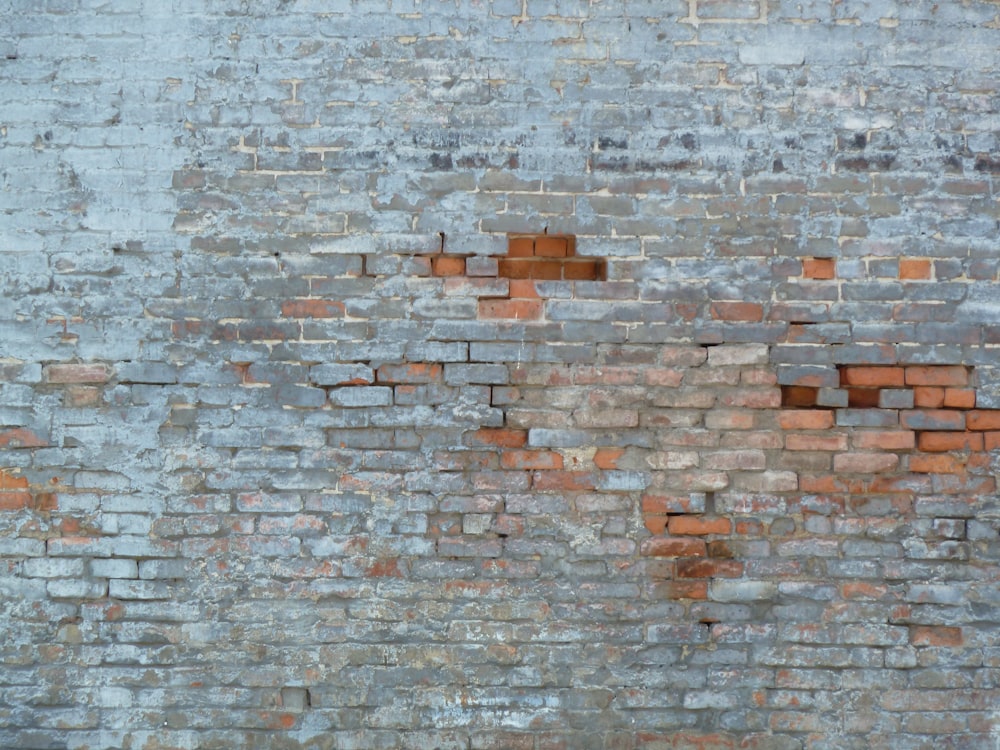 a red fire hydrant sitting in front of a brick wall