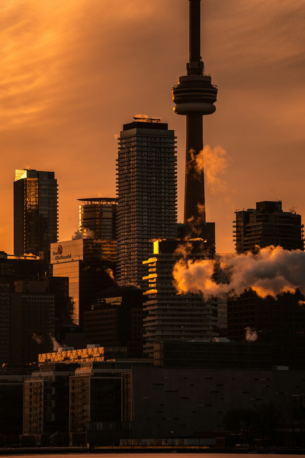 a view of a city skyline with smoke coming out of it
