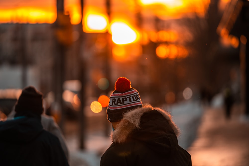 a person walking down a street with a hat on