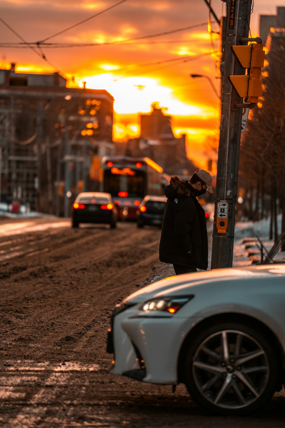 a person standing next to a car on a street