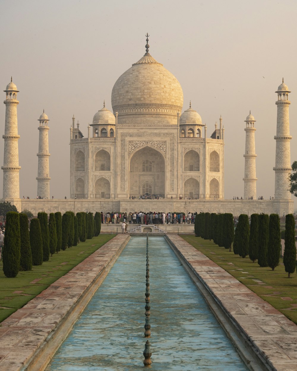 un grand bâtiment blanc avec une fontaine devant lui