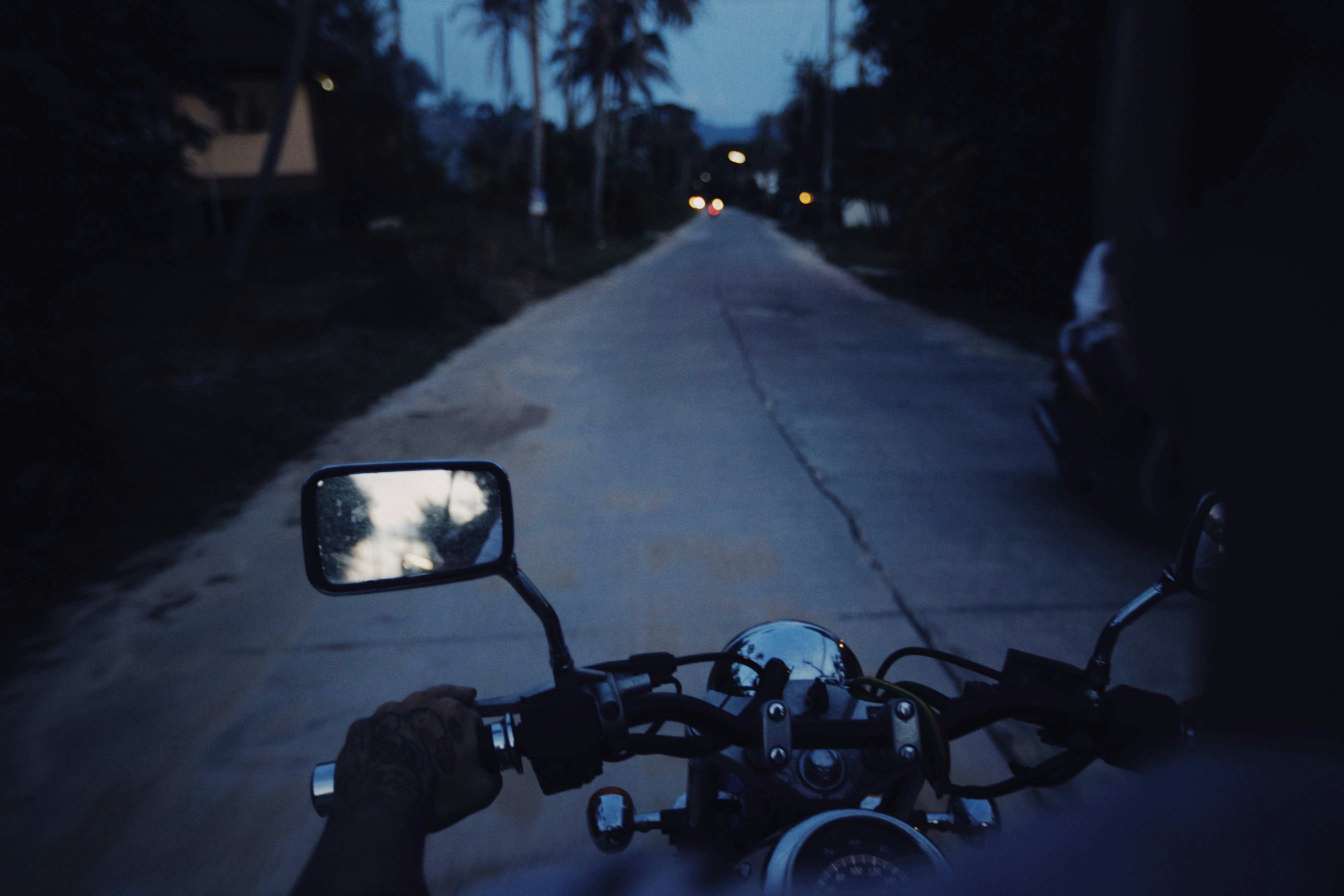 a person riding a motorcycle down a street at night