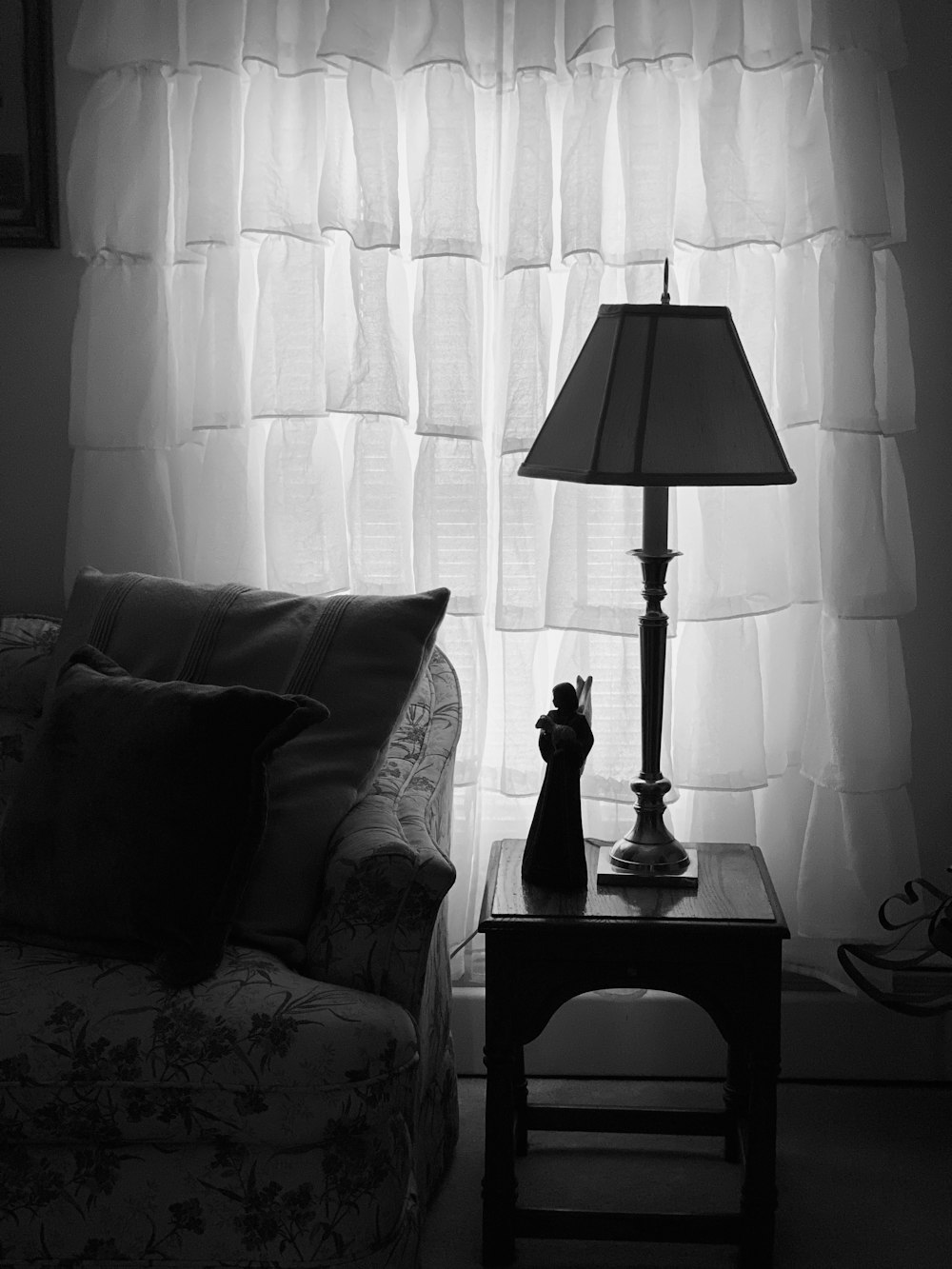 a black and white photo of a lamp and a couch