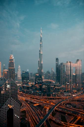 The Burj Khalifa tower rising above the illuminated skyline and highway interchange in Dubai