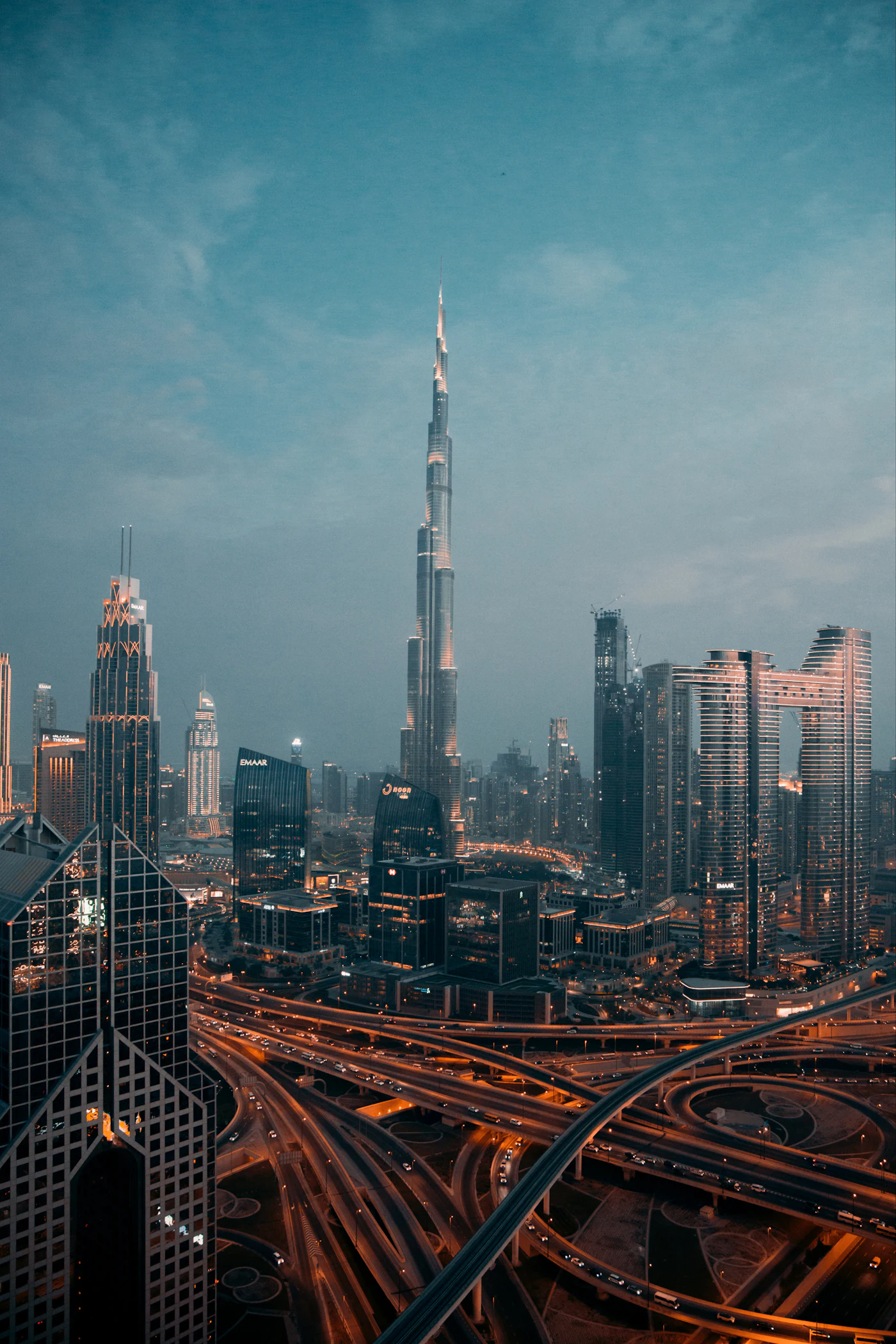 The Burj Khalifa rising above the illuminated Downtown Dubai skyline and highway interchange at night