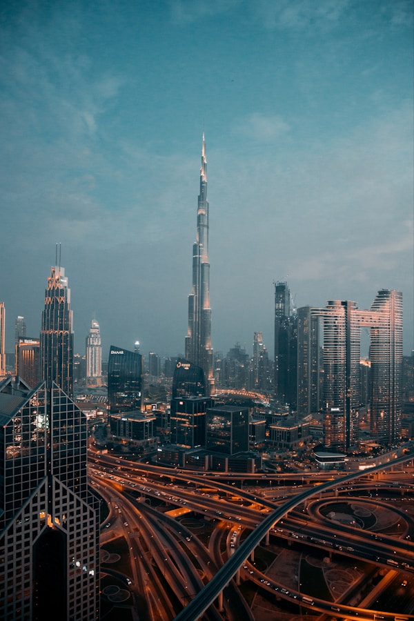 Downtown Dubai at sunset is a breathtaking sight to behold. As the sun begins to dip below the horizon, the city's iconic skyscrapers and buildings begin to shimmer in the golden light. The Burj Khalifa, the world's tallest building, stands tall and proud, casting a long shadow over the bustling streets below. As the sky turns shades of orange and blue, the city comes alive with activity. Crowds of people can be seen walking along the streets, taking in the sights and sounds of the vibrant metropolis. The air is filled with the hum of traffic, the sound of music, and the chatter of people.by Ahmed Aldaie