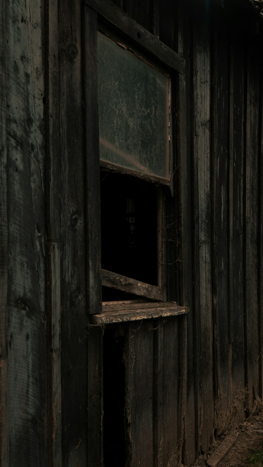 an old wooden building with a broken window