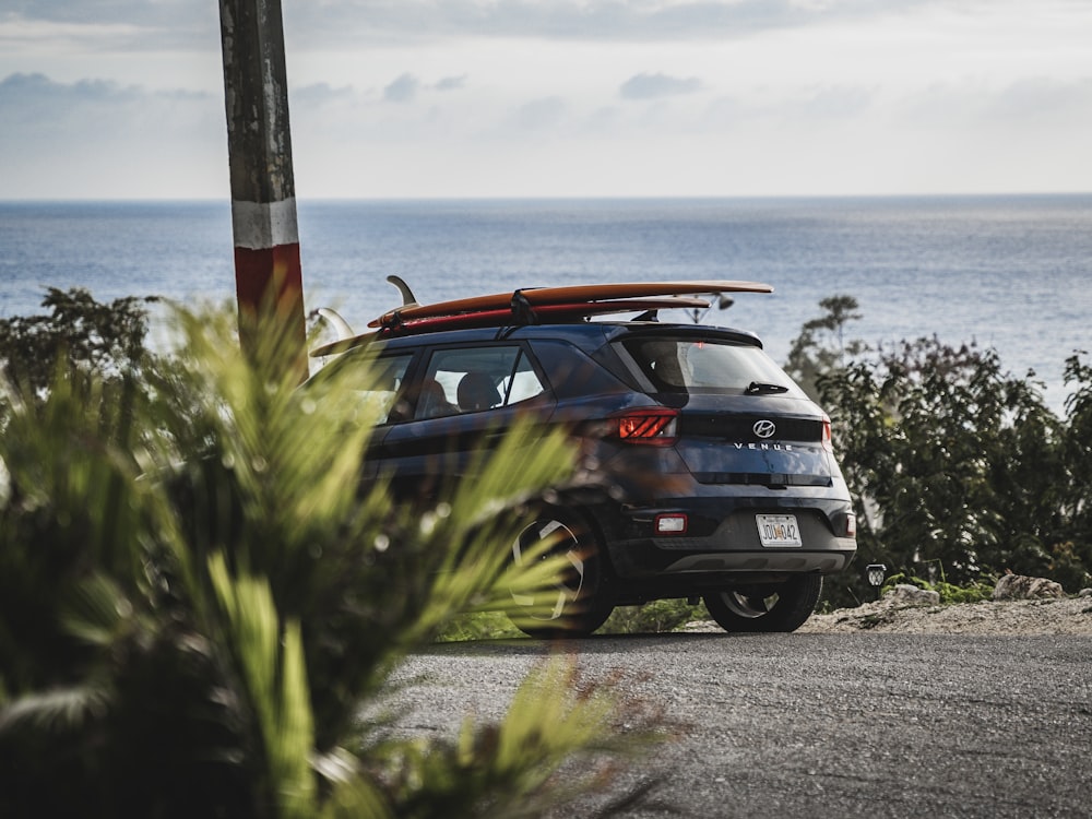 a car parked on the side of the road with a surfboard on top of