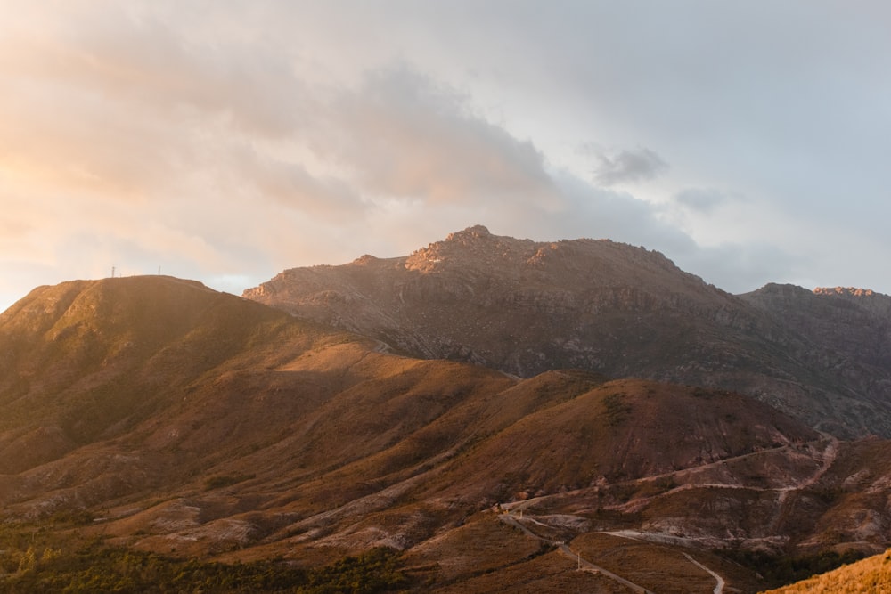 a mountain range with a winding road in the foreground