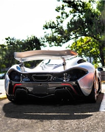 A high-performance car fitted with glossy carbon fiber parts on a sunny day.