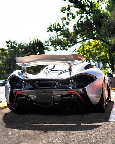 A high-performance car fitted with glossy carbon fiber parts on a sunny day.