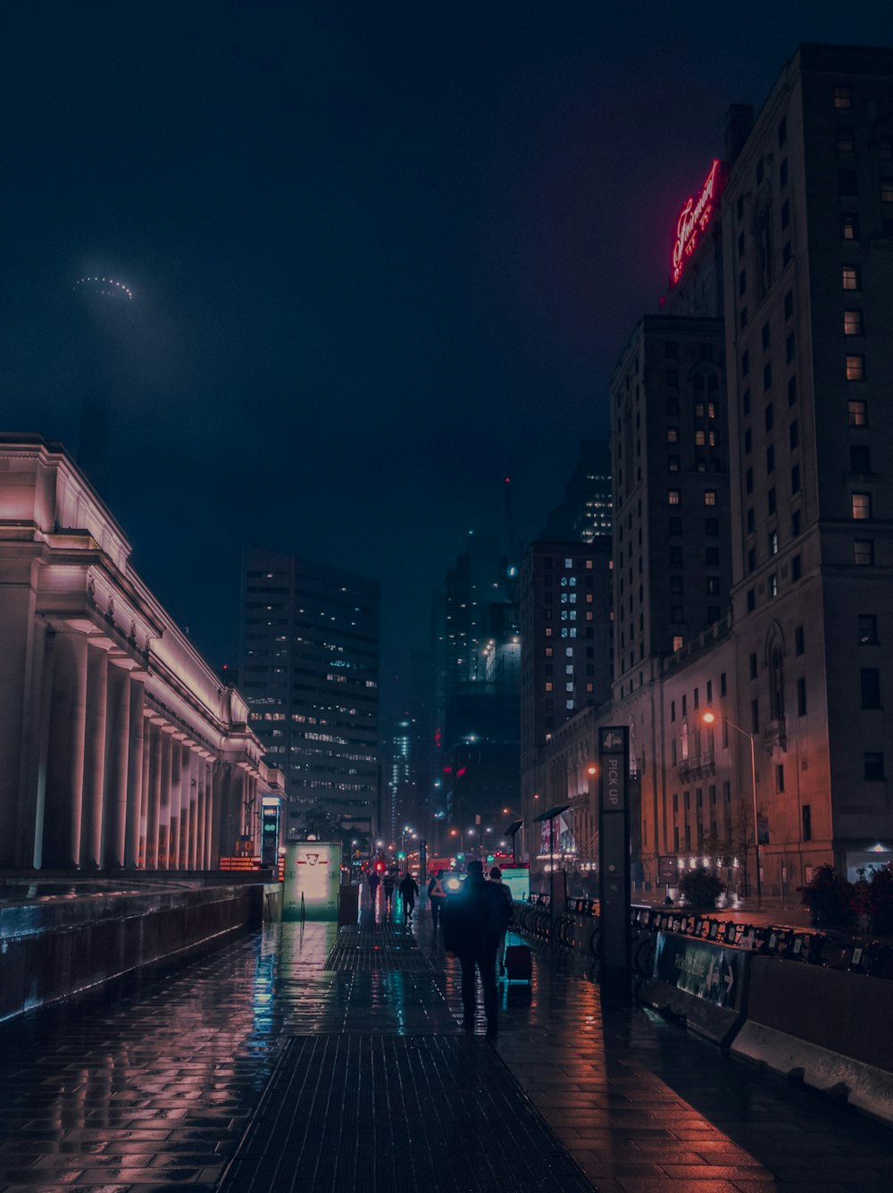 a group of people walking down a street at night