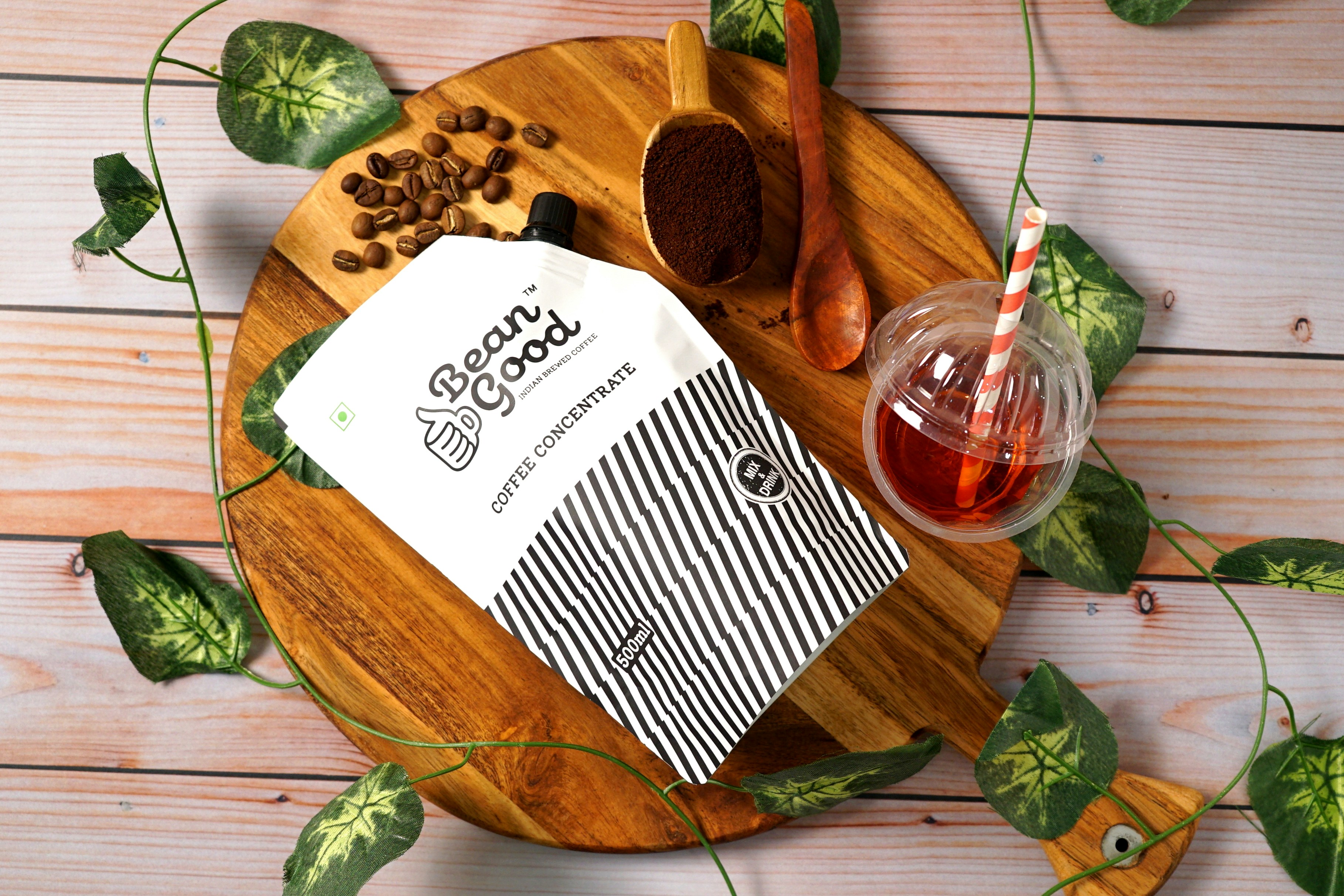 a wooden plate topped with a cup of tea next to a bag of coffee