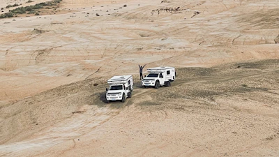 Hands raised in a moment of praise atop a hill overlooking a vast off-roading landscape.