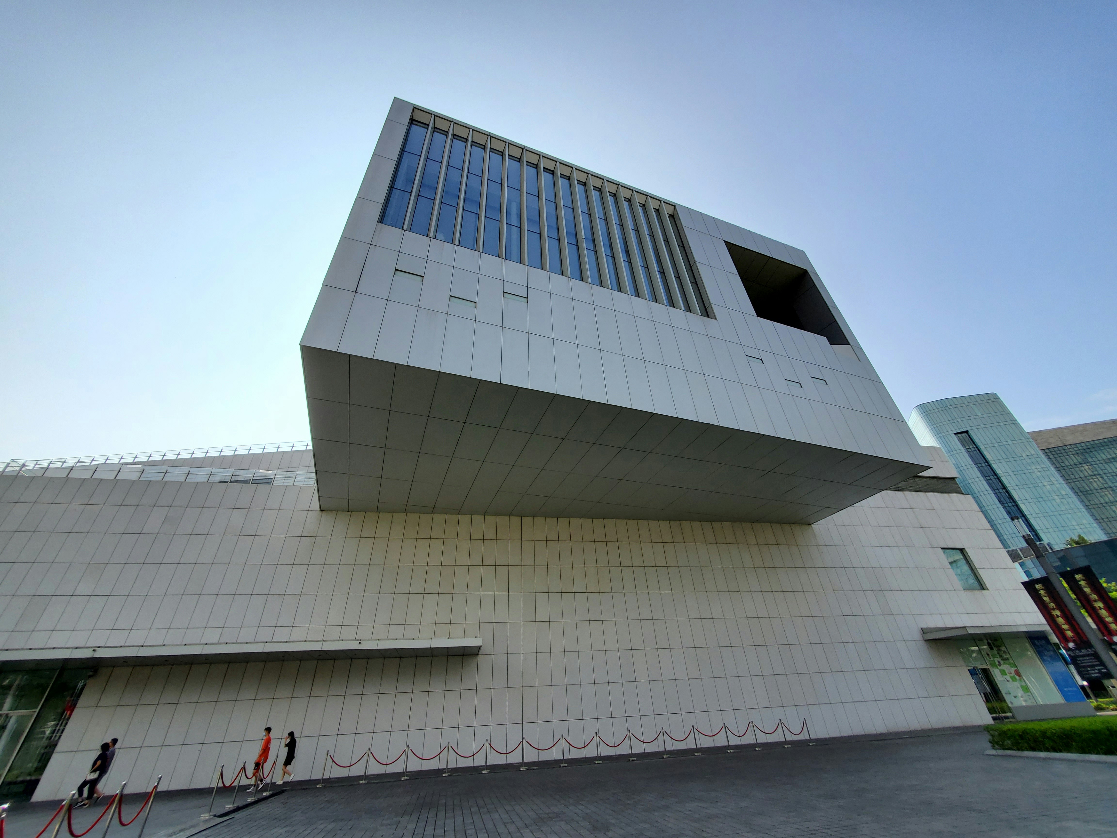a large white building with people standing outside of it