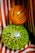 Two balloons with an animal print design are placed against a background of red and white striped fabric. The upper balloon is orange with black tiger-like stripes, while the lower balloon is lime green with a black leopard pattern.