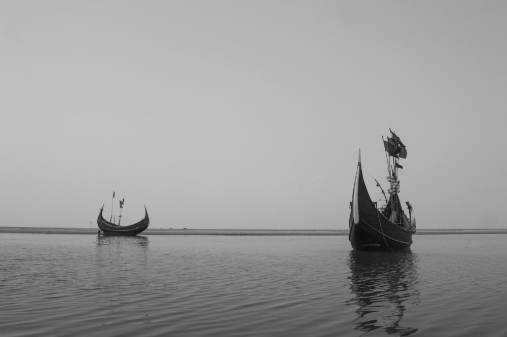 a couple of boats floating on top of a large body of water