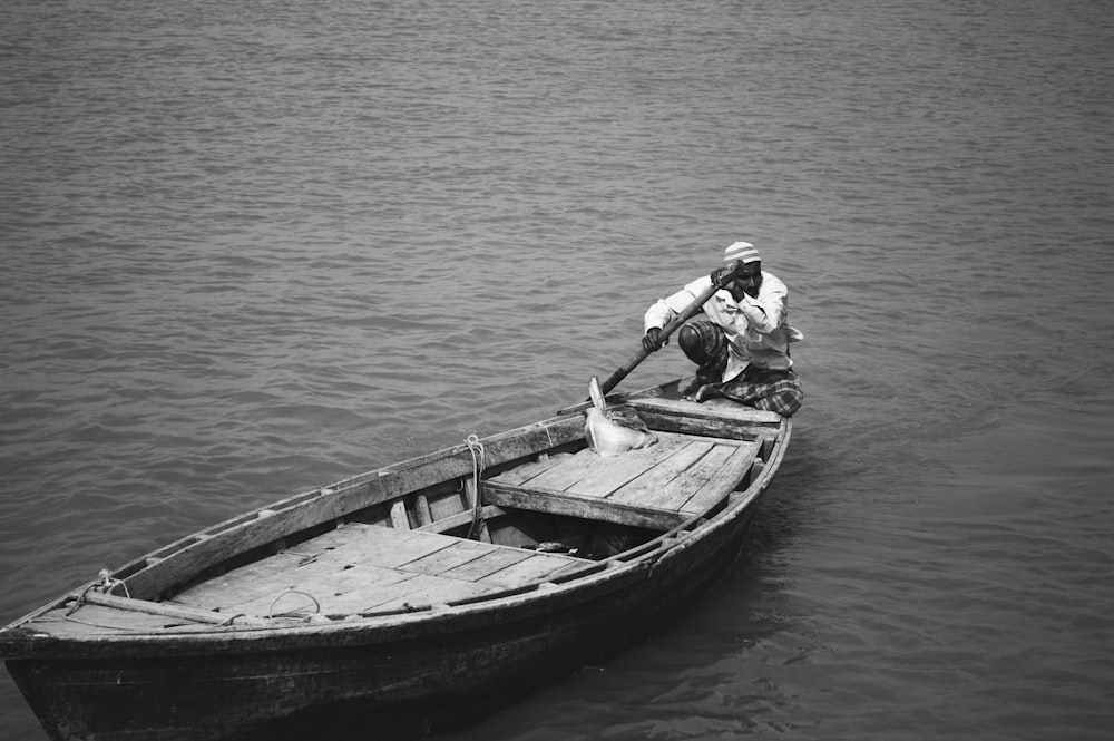 a man sitting in a small boat on a body of water