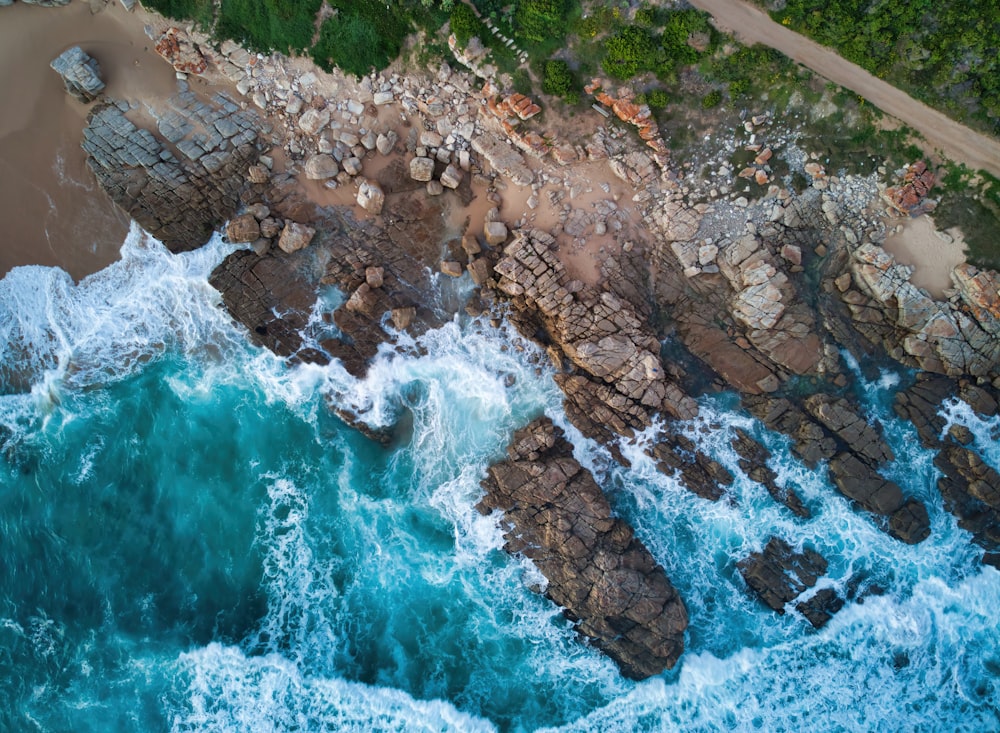 an aerial view of a rocky beach and ocean