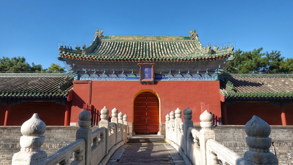 a red building with a red door and a white fence