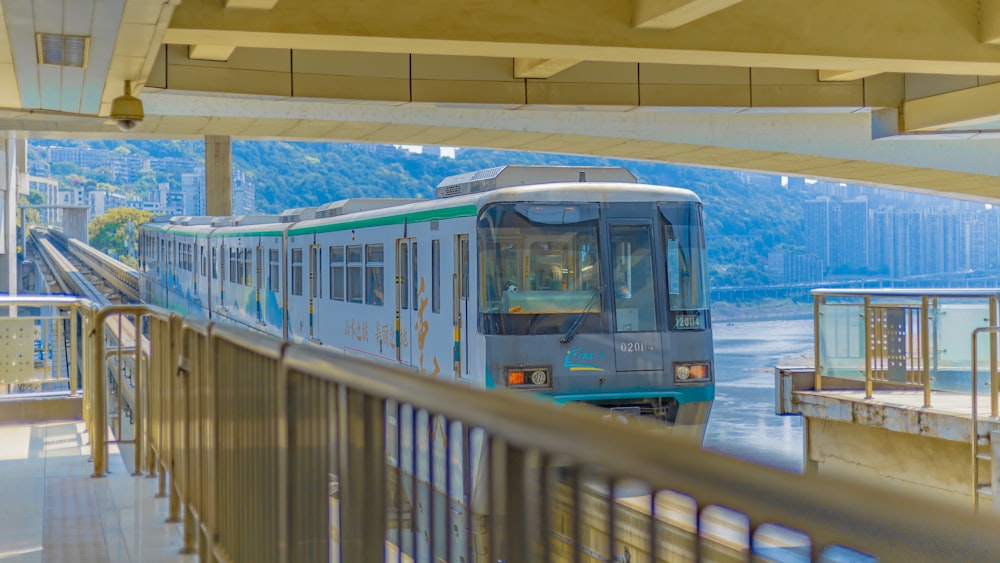 a train traveling down tracks next to a river