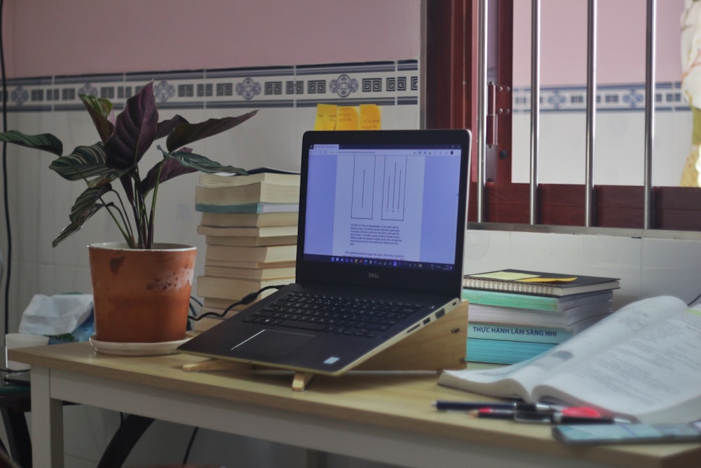 a laptop computer sitting on top of a wooden desk