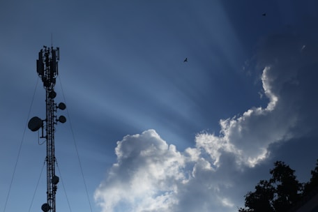 Network towers standing tall against a clear blue sky at sunrise.