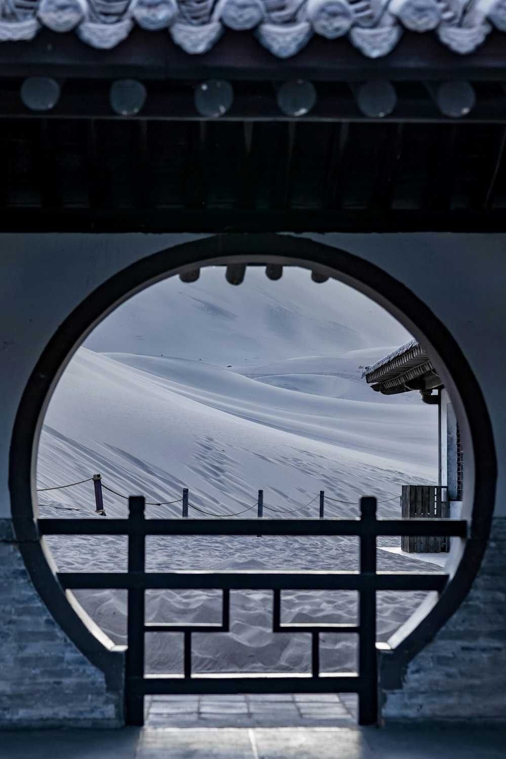 a view of a snowy landscape through a circular window