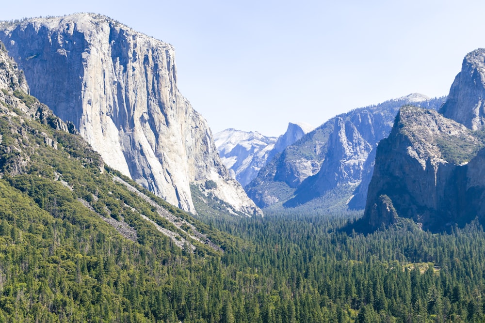 a view of a mountain range with trees and mountains in the background