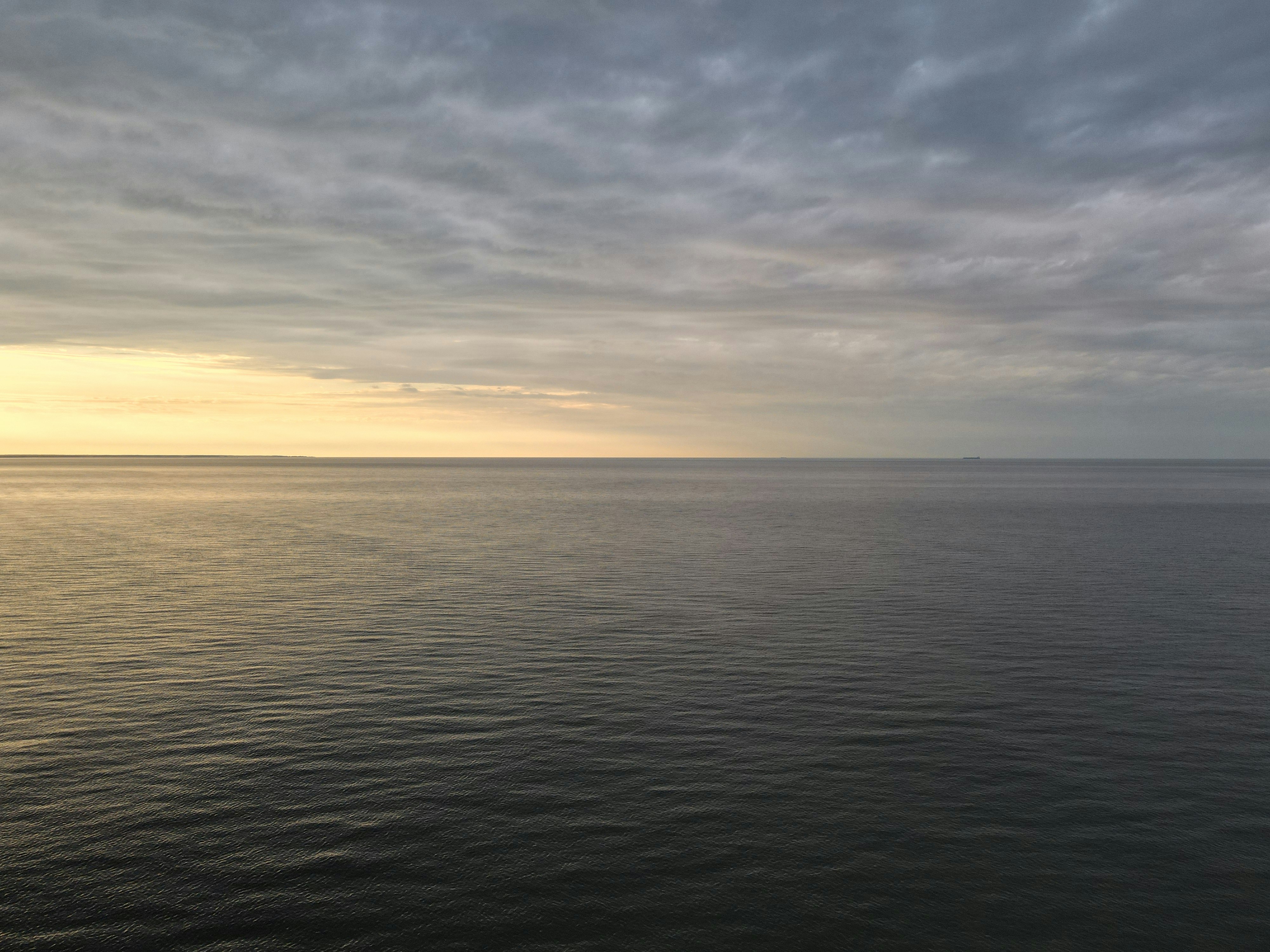 a large body of water under a cloudy sky