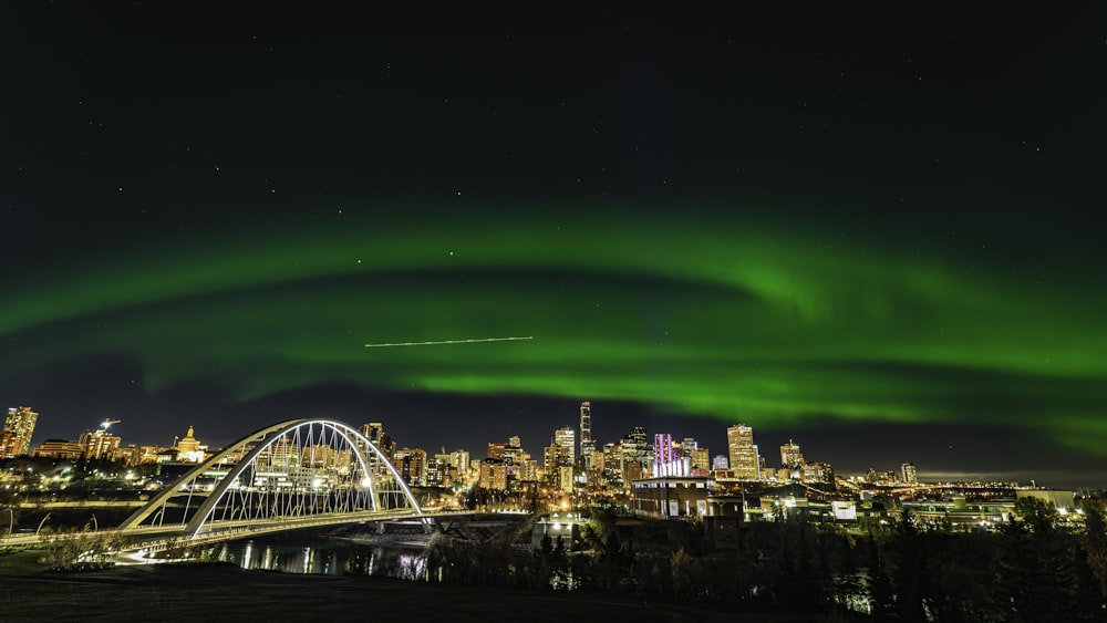 uma aurora verde pairava sobre uma cidade à noite