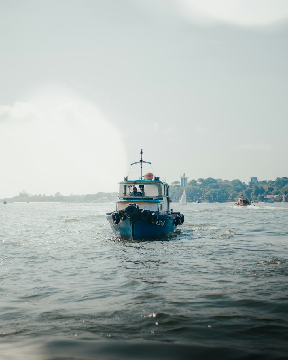 a small blue boat in the middle of a body of water