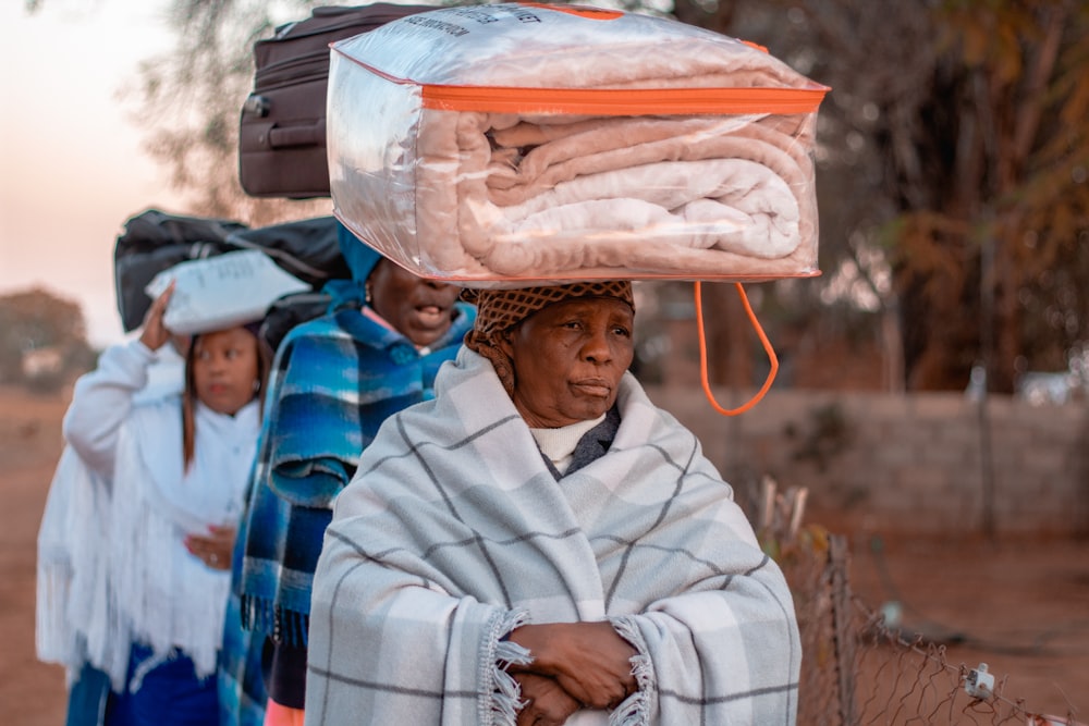 a group of women walking down a dirt road