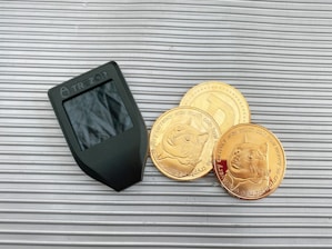 a digital camera next to a pile of gold coins