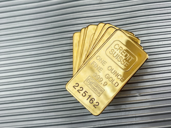 Gold cards against a metal wall — representing the variety of gold product forms available to investors