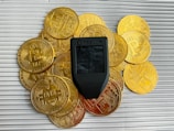 a cell phone sitting on top of a pile of gold coins