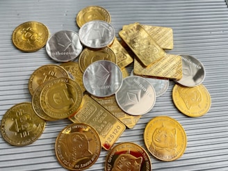 a pile of gold and silver coins sitting on top of a table