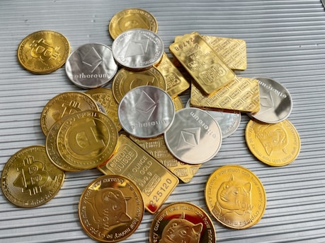 a pile of gold and silver coins sitting on top of a table