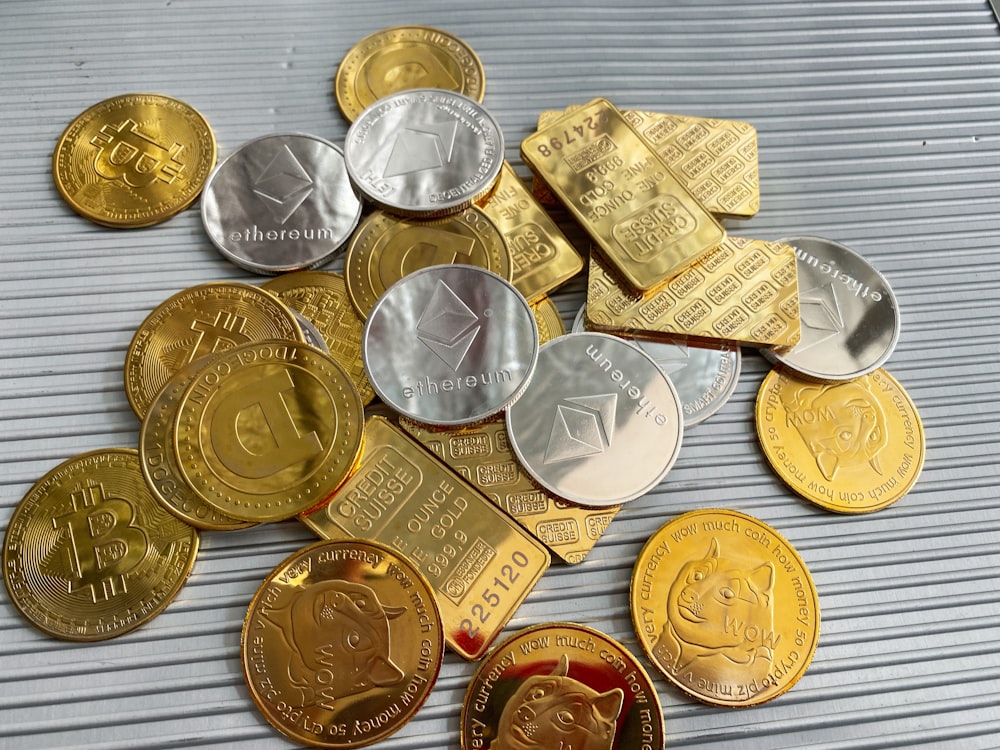 a pile of gold and silver coins sitting on top of a table
