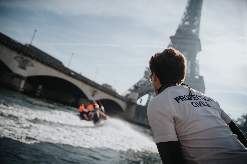 a man riding a boat in front of the eiffel tower